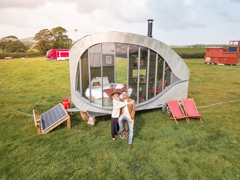 Couple glamping in Wales with the pod in the background