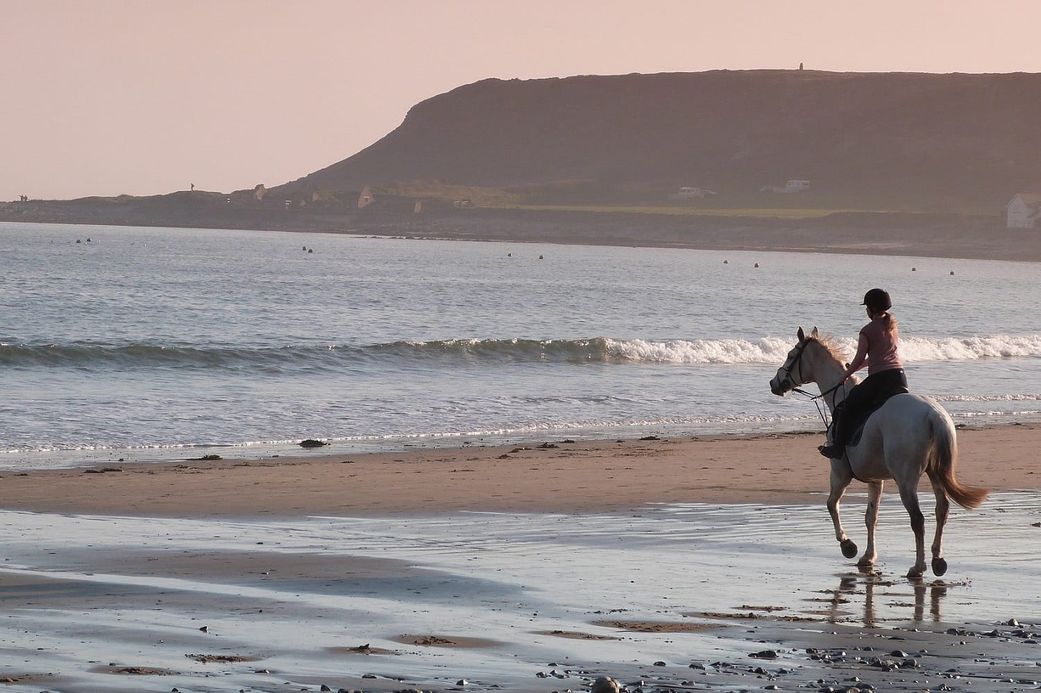 person riding a horse on a beach in wales